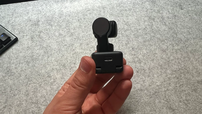 Insta360 Link in a reviewer's hand showing the back of the camera